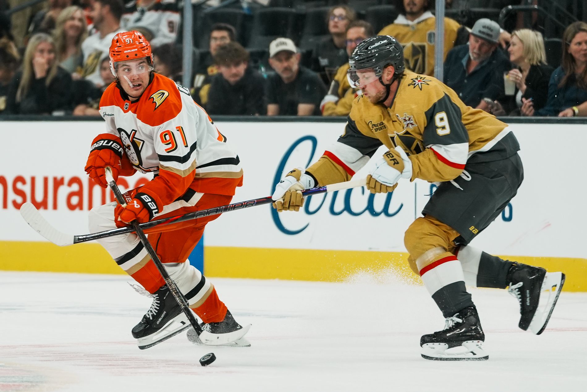 Leo Carlson maneuvers the puck away from Jack Eichel in a strategic play.