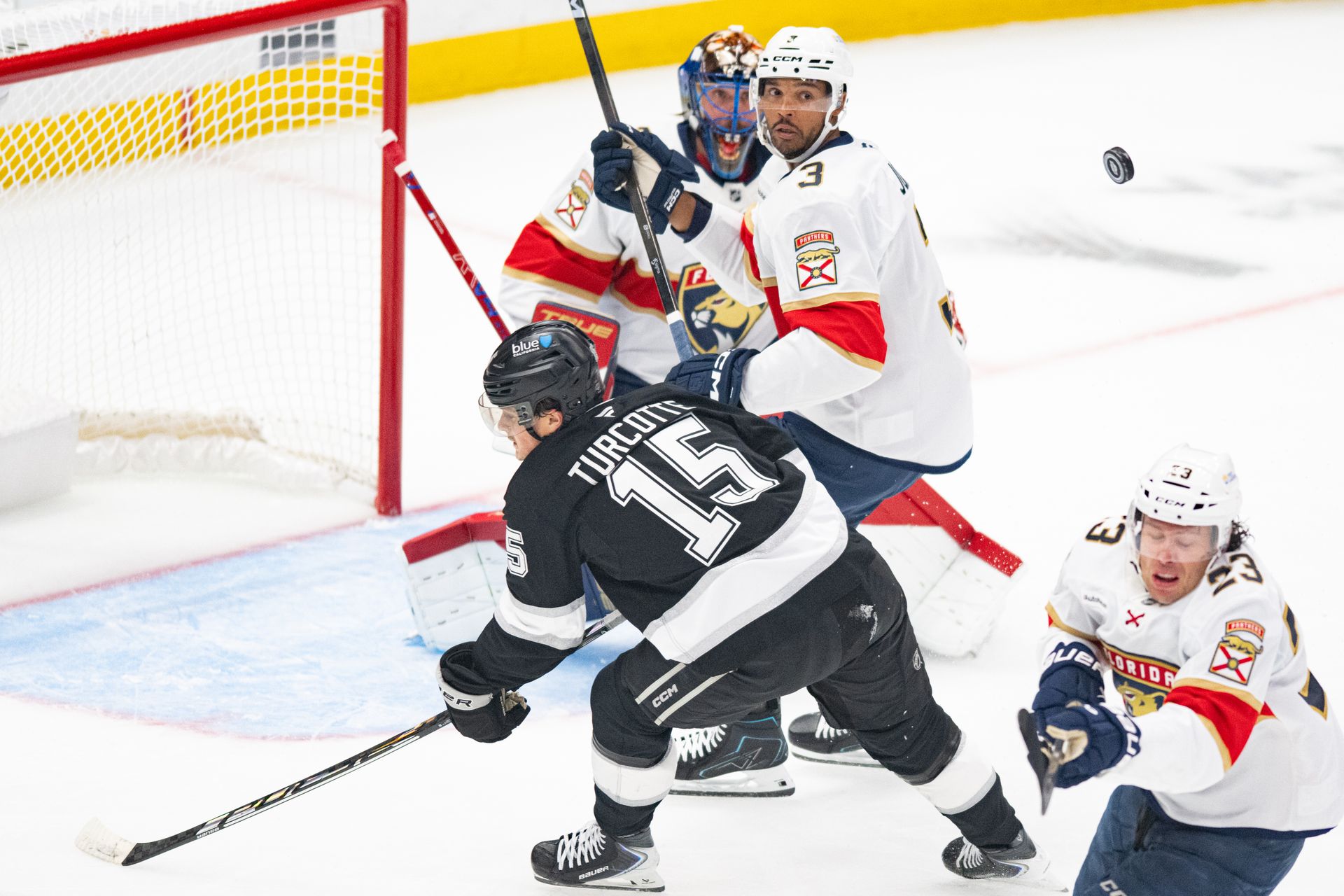 Alex Turcotte hustles for the puck in NHL matchup.