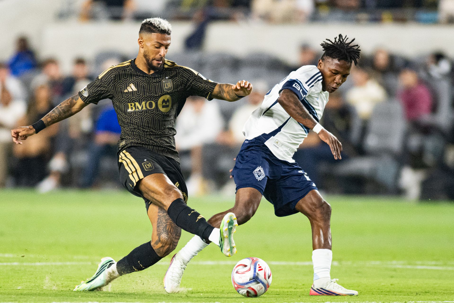 Denis Bouanga (99) passes the ball in MLS match