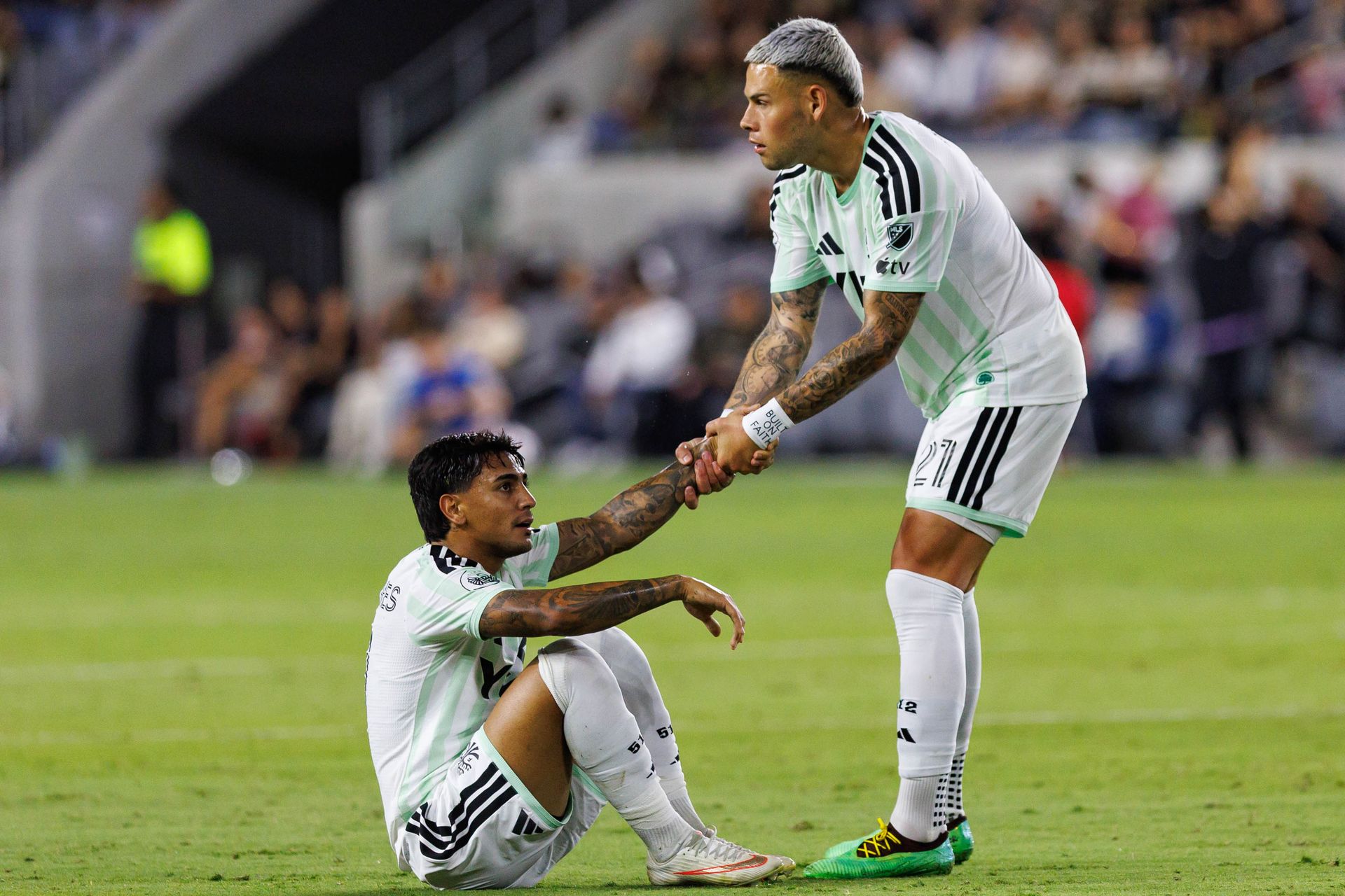 Christian Ramirez helps Facundo Torres to his feet