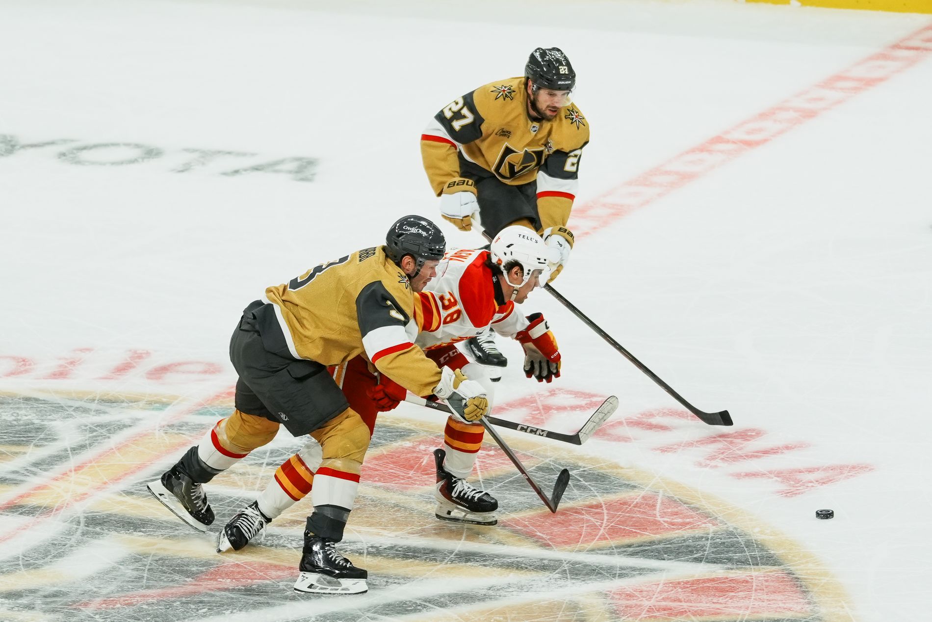 Brayden McNabb and Shea Theodore race Jonathan Castanga to the puck
