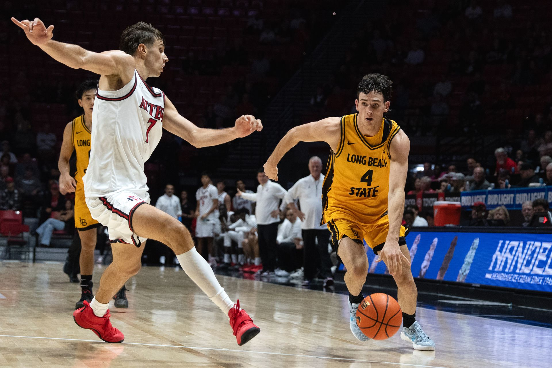 Long Beach State guard McCaden Adams drives past defenders