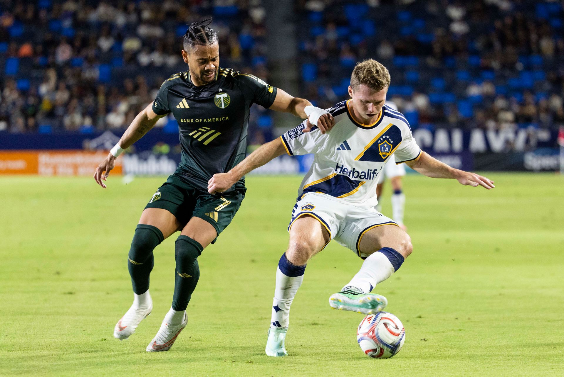 John Nelson carries the ball against Ariel Lassiter